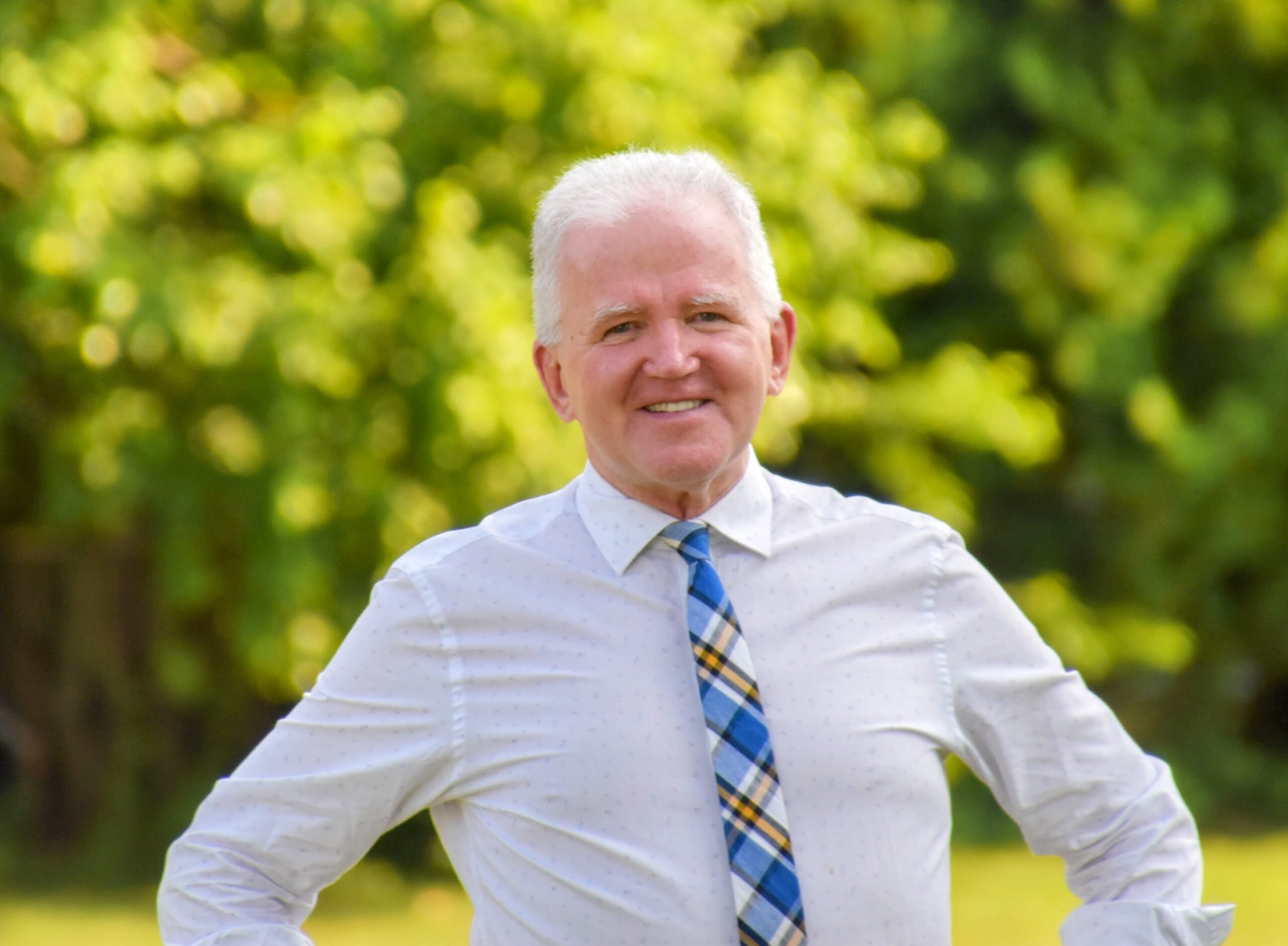 Griffin Morse, interim head of school, standing in field and smiling